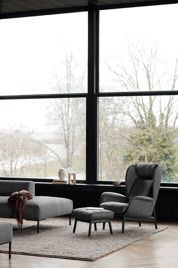 Padova Lænestol og fodskammel i læderet Nature Warm Stone Grey med sorte ben i moderne stue