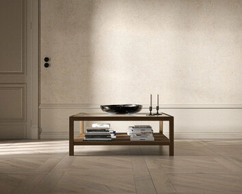 2000 Plus Sofabord i størrelsen 107x107 centimeter med en skål, lysestager og bøger