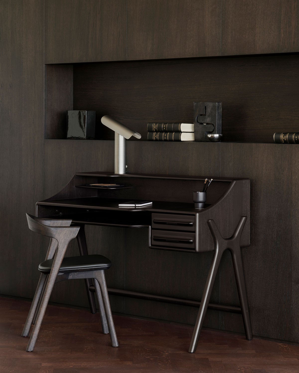 Flow Skrivebord i mahogni i farven Rose Brown i et rum beklædt med mørkt træ