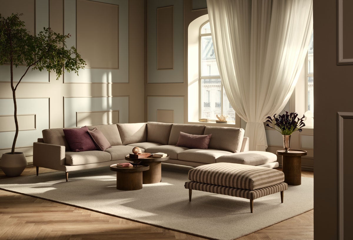 Veneda hjørnesofa 6-personers med åbent afslutning til højre i et beige stof. Hjørnesofaen står i en dæmpet stue med moderne indretning.
