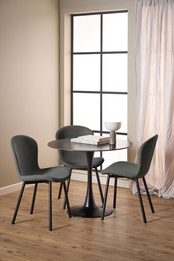 Tre Esra Stole i stoffet Apia Mørkegrå som står omkring et rundt spisebord