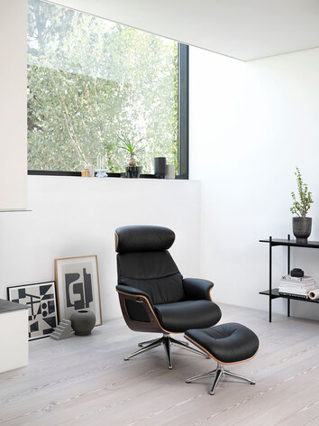 Clement Lænestol og fodskammel med finérsider i læderet Savoy i farven Platin Black i moderne stue