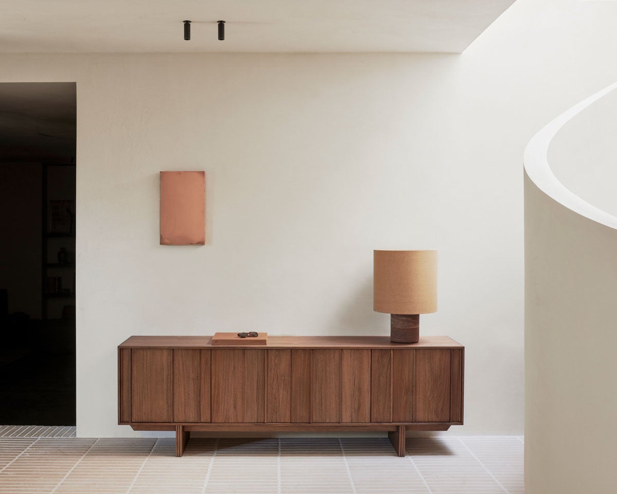 Pillar Skænk med en bredde på 220 centimeter dekoreret med en bog og en bordlampe