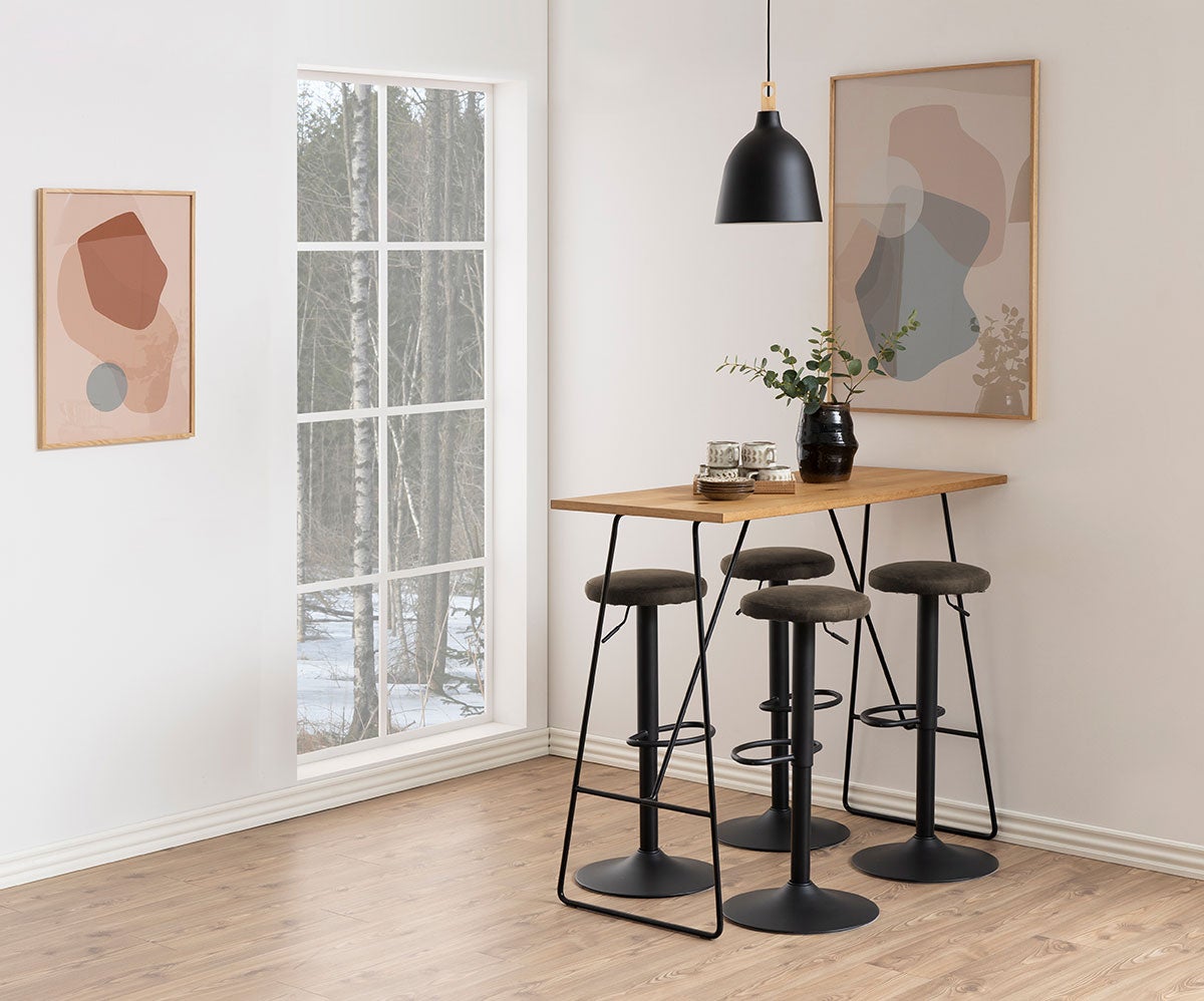 Fire Finch Barpaller i stoffet Preston Antracit som står rundt om et rektangulært barborde i træ. Barbordet er dekoreret med porcelæn og en vase.