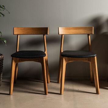 To K5-stole i oliebehandlet eg mod en grå væg