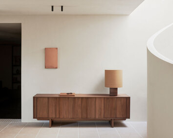 Pillar Skænk med en bredde på 220 centimeter dekoreret med en bog og en bordlampe