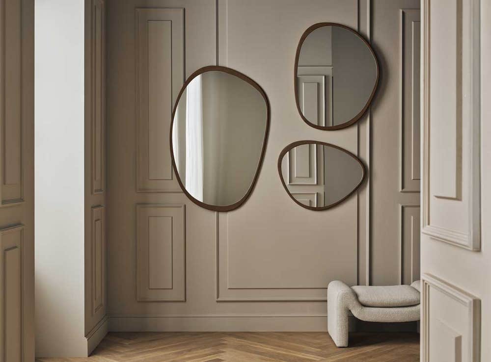 Bolia-Elope-Mirror-Collection-Dark-Oiled-Oak-Lifestyle.jpg Elope spejl i forskellige størrelser i mørkolieret eg, der hænger på en beige væg.