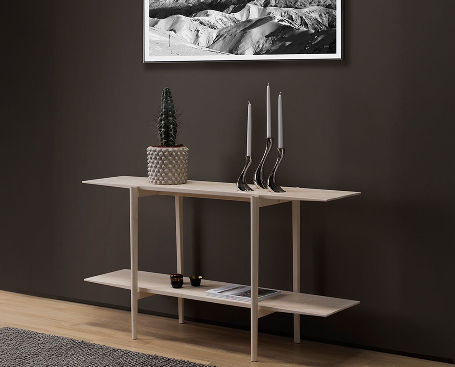 Calpe Sideboard i hvidolieret eg dekoreret med en krukke, lysestager, fyrfadsstager og magasiner.