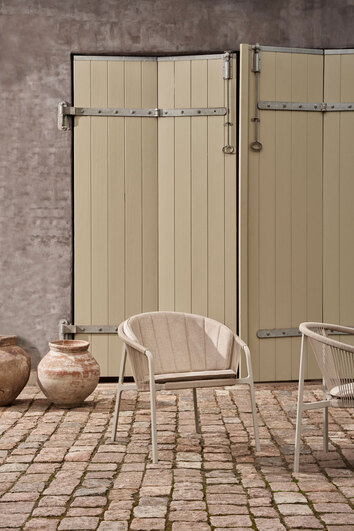 Vipp 712 Lagrasse Loungelænestol med siddehynde og ryghynde på en solrig terrasse