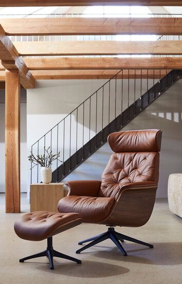 Volden Lænestol og fodskammel i læderet Modern Cognac Brown med ben i sort aluminium i stue med lysindfald