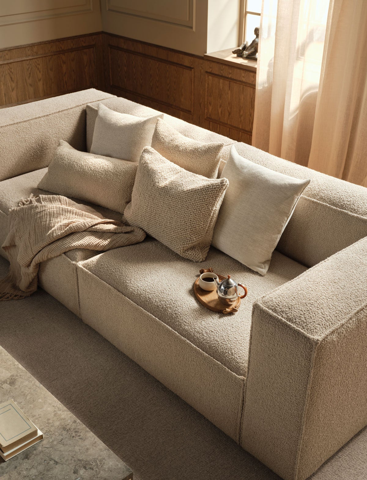 Classic pude i forskellige stoffer og størrelser på en beige sofa.