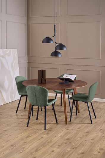 Fire Esra Stole i stoffet Apia Grøn som står omkring et rundt spisebord i mørkt træ