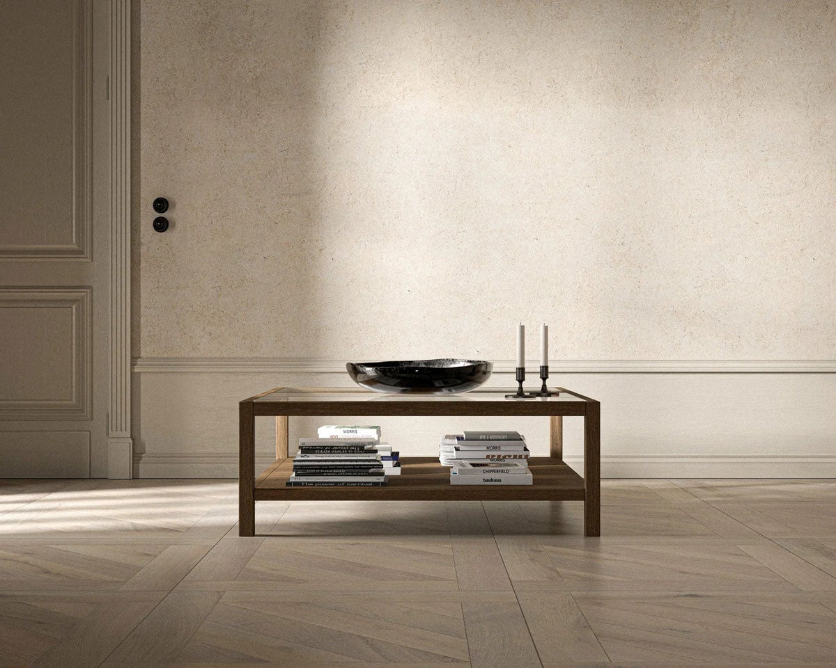 2000 Plus Sofabord i størrelsen 107x107 centimeter med en skål, lysestager og bøger