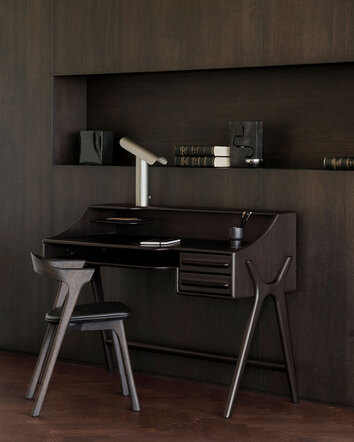 Flow Skrivebord i mahogni i farven Rose Brown i et rum beklædt med mørkt træ