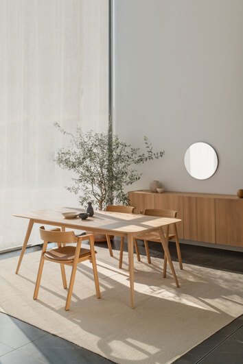 Tre Flip Stole i natur­lakeret eg omkring et rektangulært spisebord i en spisestue med et beige tæppe